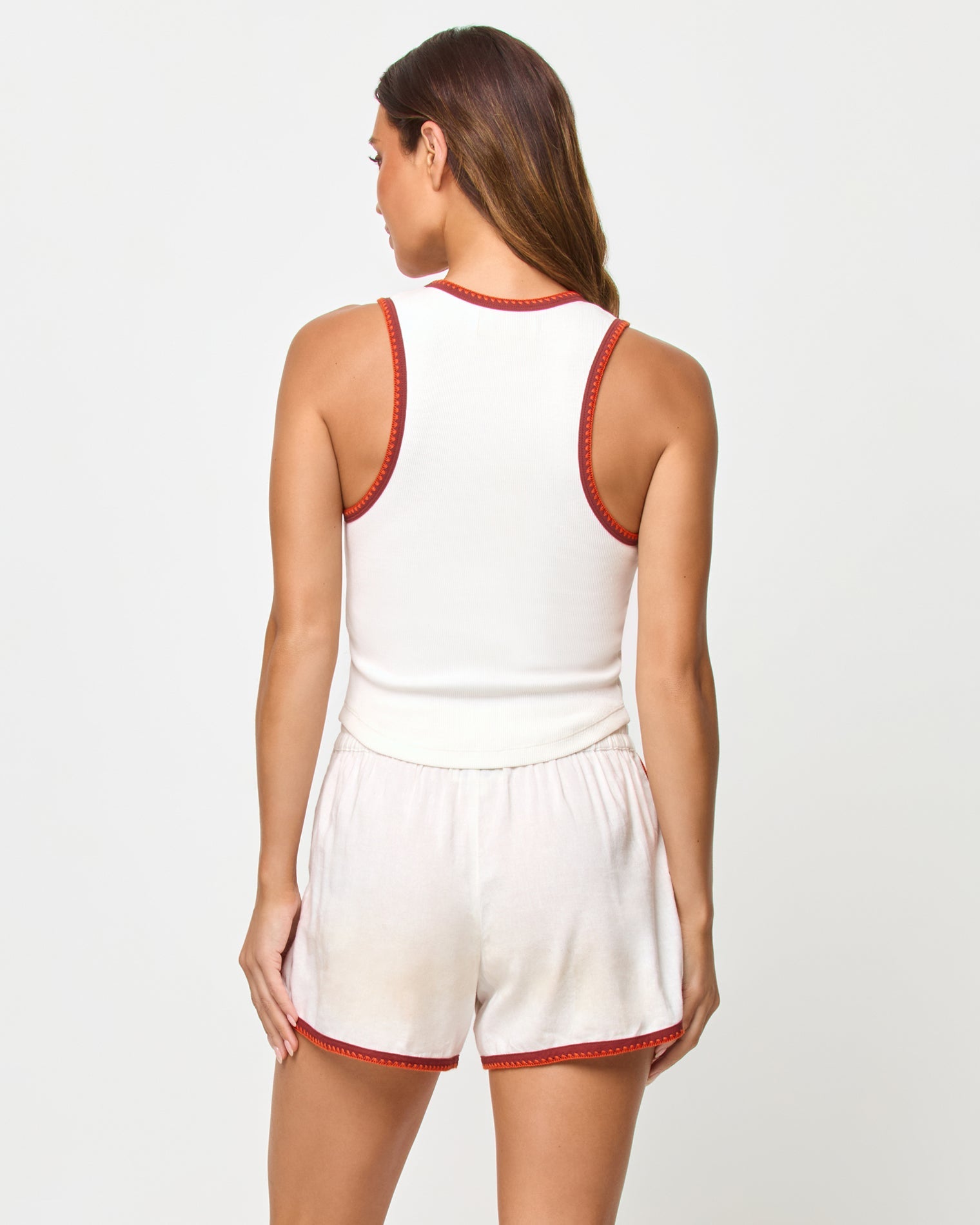 Back studio view of the Ash Tank and Rune Short in Cream Fig Poppy, a cream ribbed crop tank with rust and terracotta crochet trim at the back neckline and racerback straps paired with matching cream runner shorts with rust crochet trim at the hem.