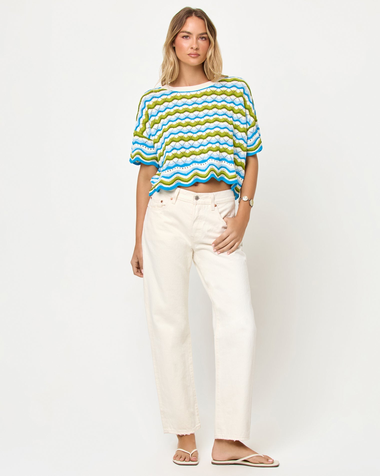 LSPACE Sunchaser top in Island Breeze, front view on model styled with white pants.
