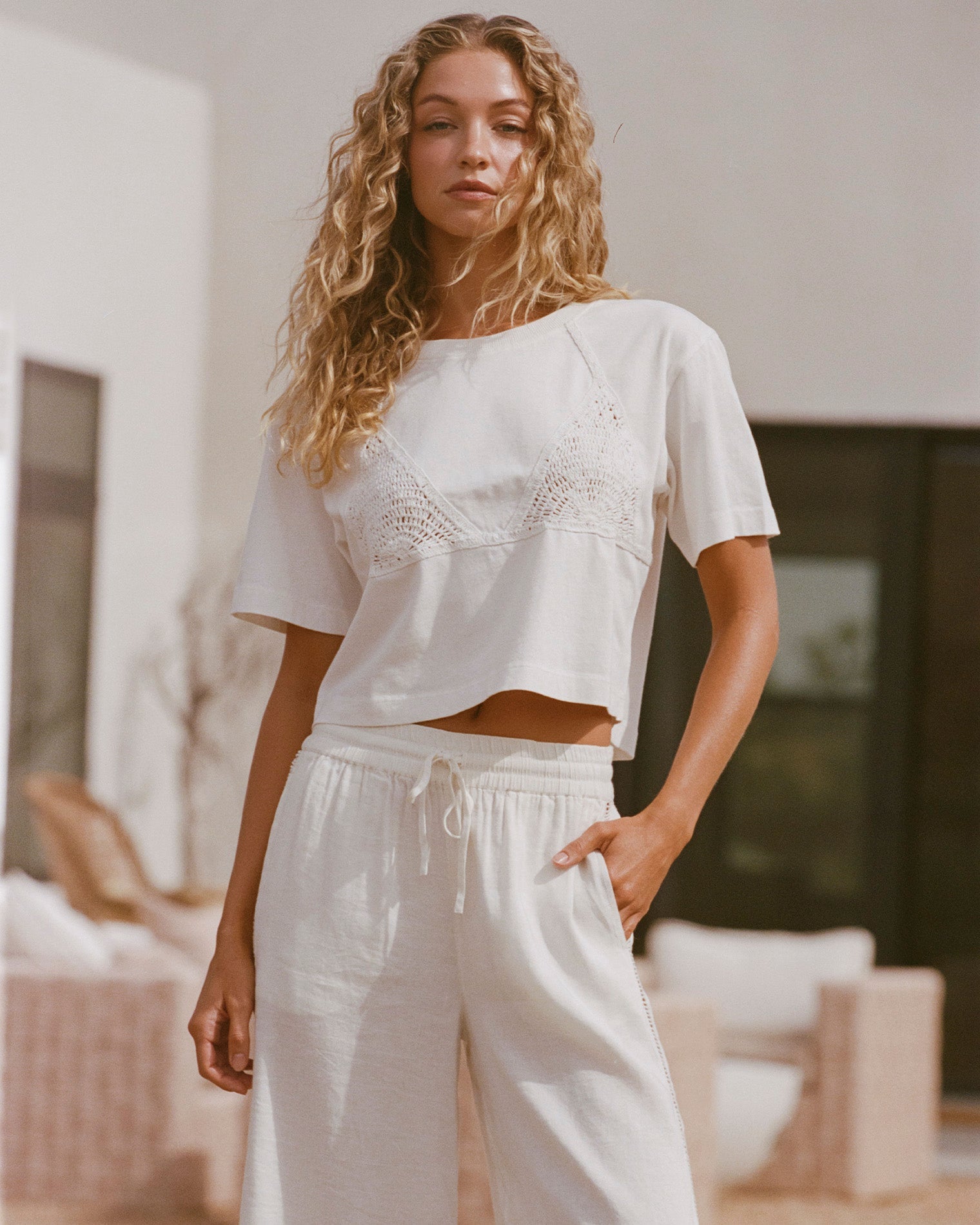 Cream Natural | Badge:New Arrival_#B2AC88_#ffffff'
Lifestyle image of model wearing the LSPACE Core Top in cream-natural, a cropped short-sleeve top in cream.