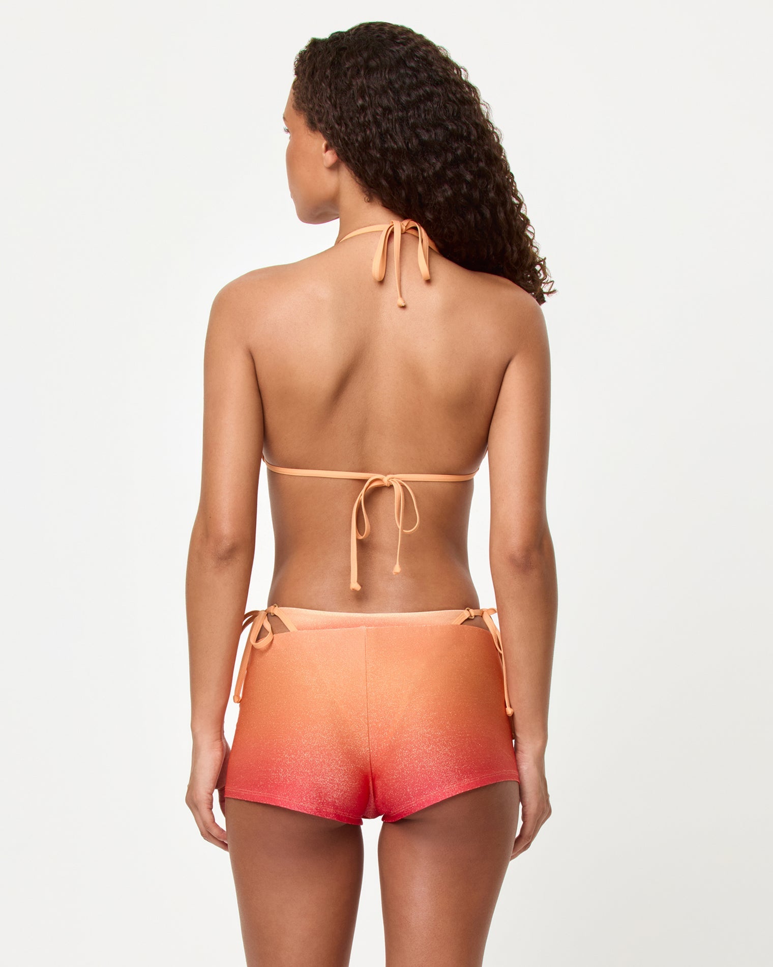 Back view of a model wearing the LSPACE Ocaso Caliente Short with the matching Banning Bikini top.