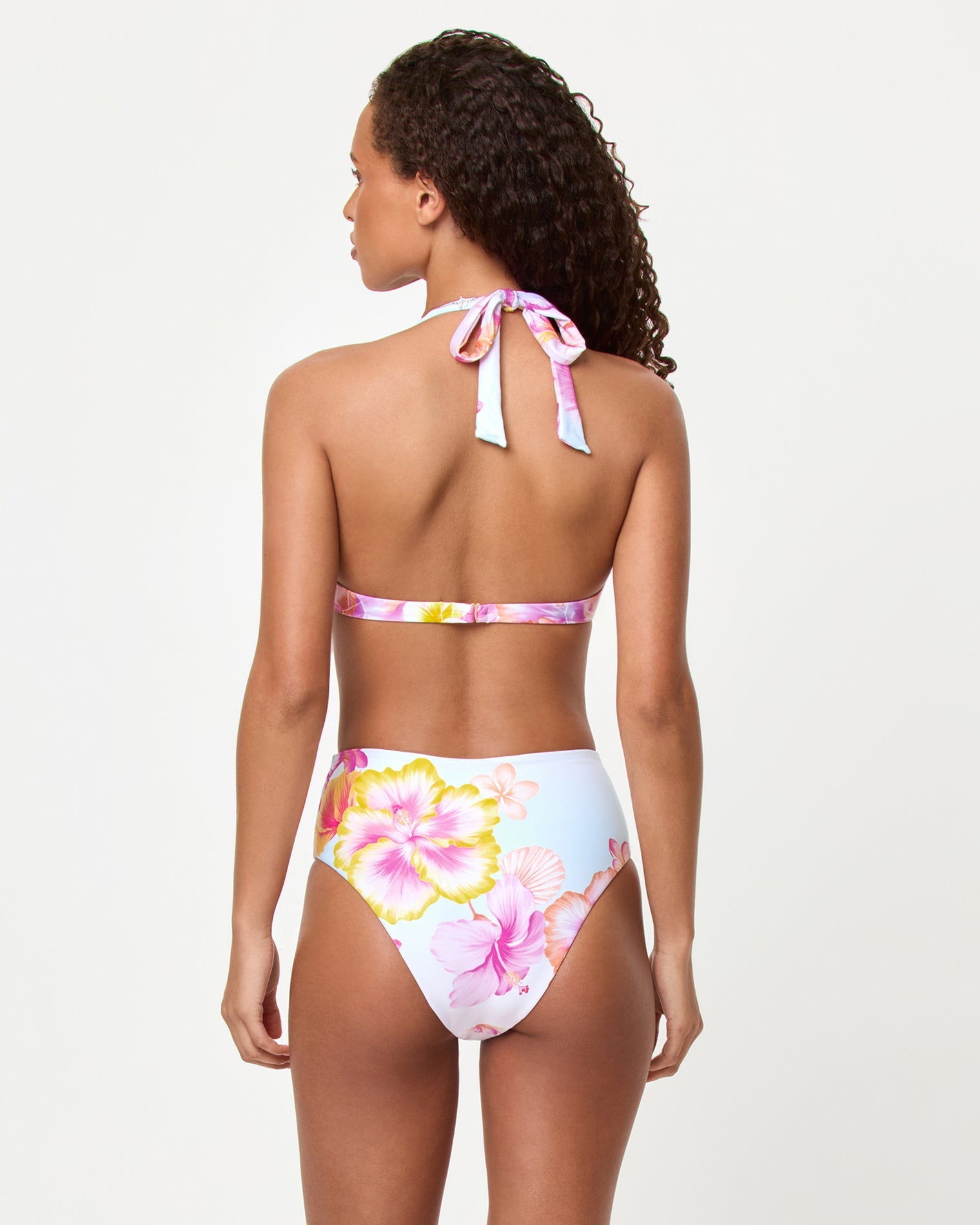 LSPACE Soleil bikini bottom in Hibiscus And Plumeria Oh My, back view on model.