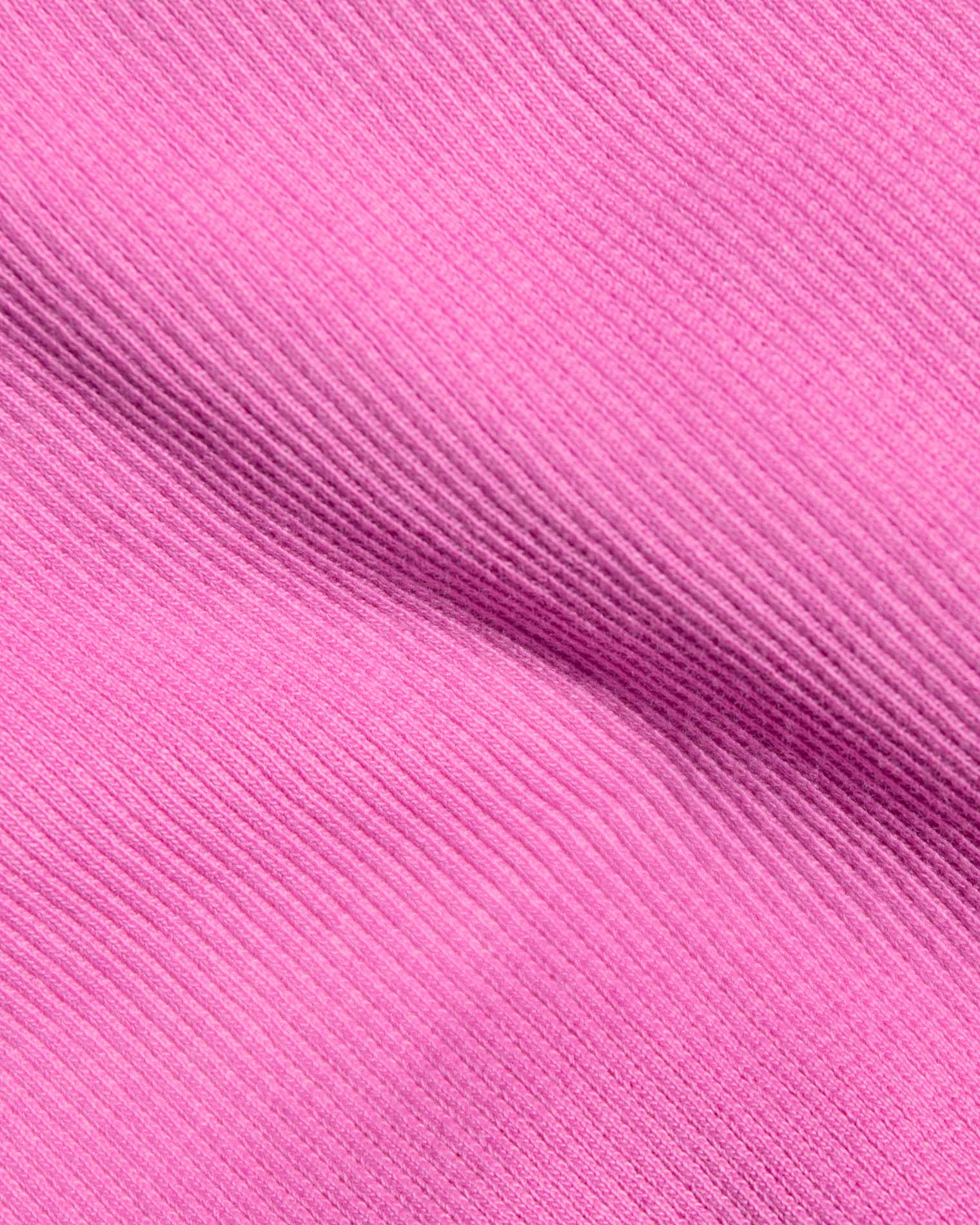 A close-up of bright pink ribbed fabric.