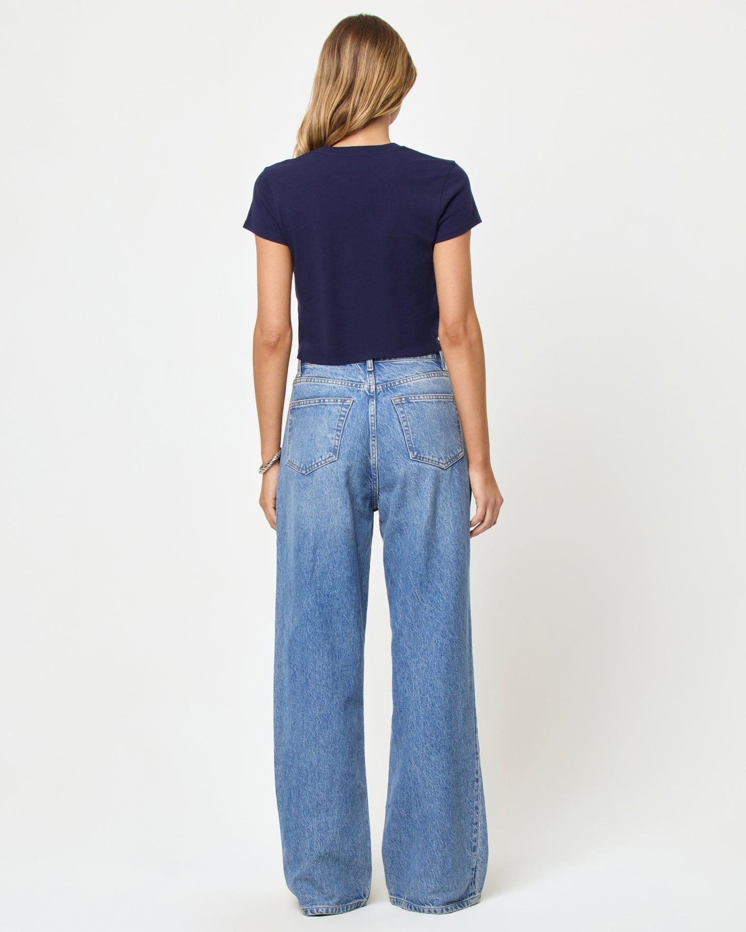 Back view of model wearing the LSPACE Merci Baby Tee in made in California midnight blue, a navy cropped baby tee.