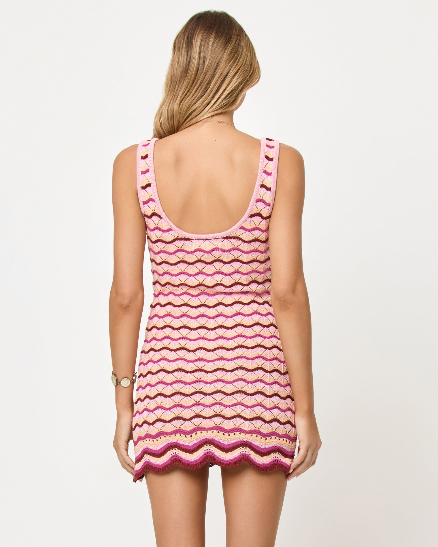 Back view of model wearing the LSPACE Sunchaser Dress in berry spritz, a crochet mini dress.