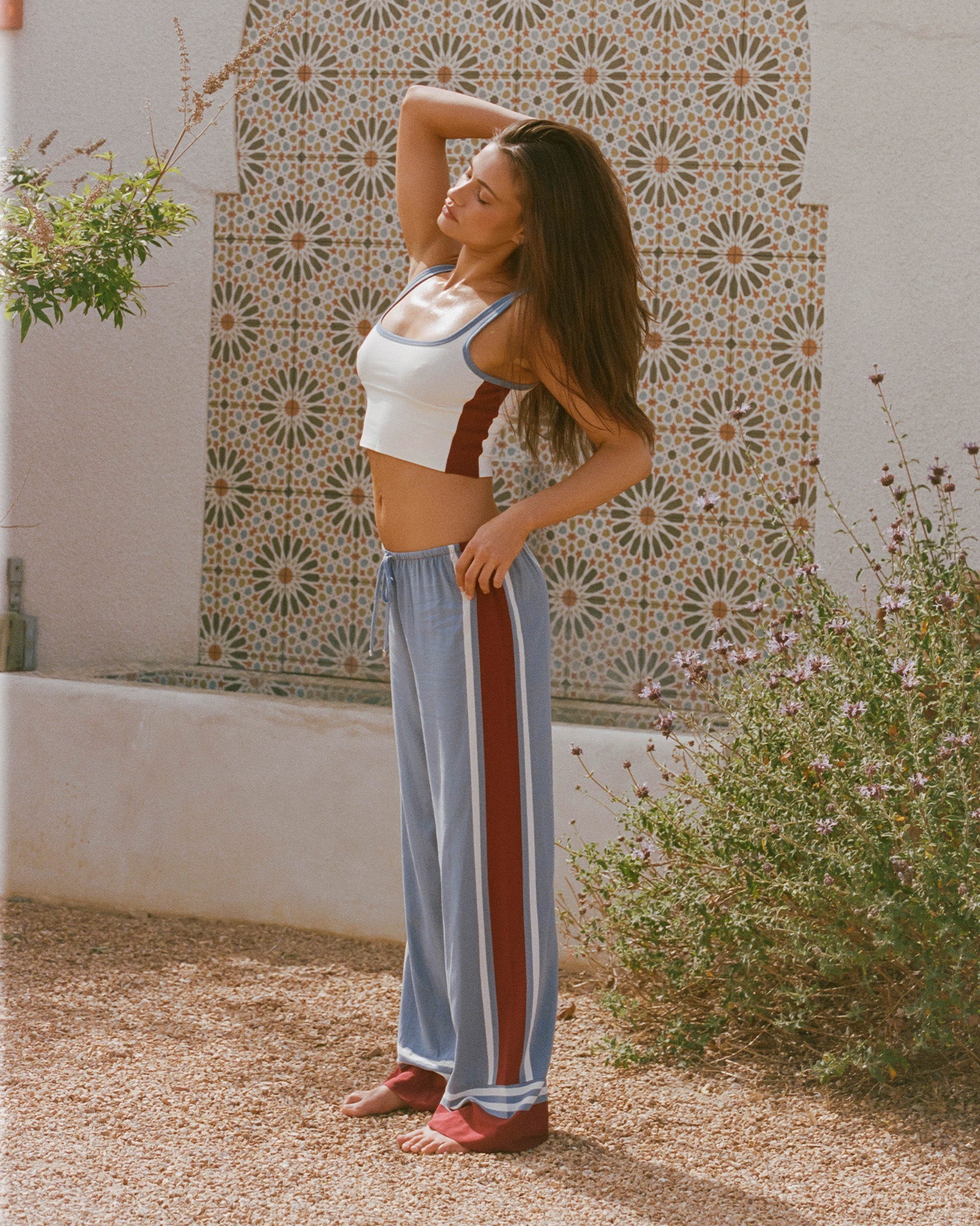 Unwind Stripe | Badge:New Arrival_#B2AC88_#ffffff'
Lifestyle image of model wearing the LSPACE Unwind Pant in unwind stripe, a relaxed-fit striped pant.